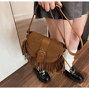 Detailed view of bohemian brown tassel saddle bag with vintage hardware and fringe