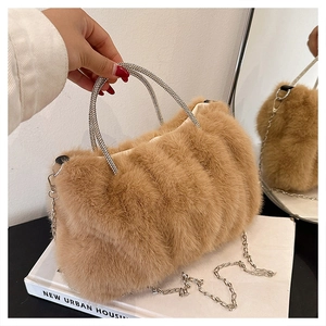 Vue détaillée de la texture en fausse fourrure camel et de l'anse en strass de ce sac
