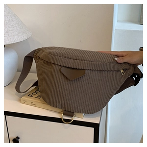 Detailed close-up of brown corduroy chest bag featuring a triangular patch and D-ring