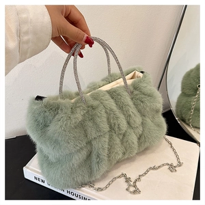 Détail du sac à main en peluche vert sauge avec poignées en strass et chaîne argentée