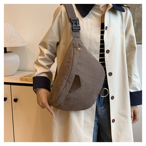 Detail of dark brown corduroy waist bag showing vertical texture and adjustable strap