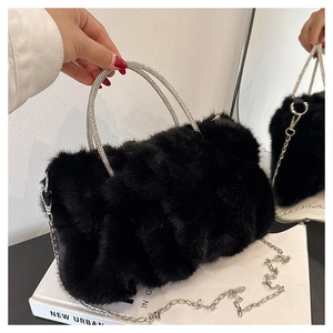 Vue détaillée du sac en fausse fourrure noire avec poignées en strass et une chaîne