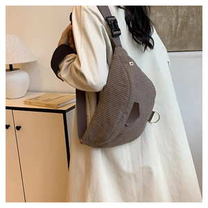 Detail view of dark brown corduroy chest bag with adjustable strap and metallic D-ring