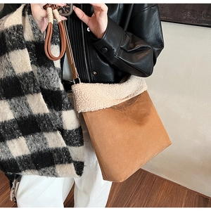 Dettaglio del bordo in lana d'agnello e texture in pelle scamosciata marrone su borsa a tracolla