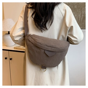 Detailed close-up of brown corduroy half-moon crossbody bag with golden metal ring detail