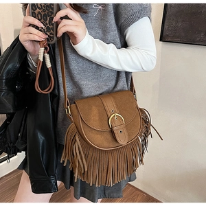 Detail of vintage brown tassel crossbody bag with matte finish and bohemian fringe
