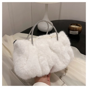 Détail d'un sac en fausse fourrure blanche avec poignées en strass et chaîne argentée