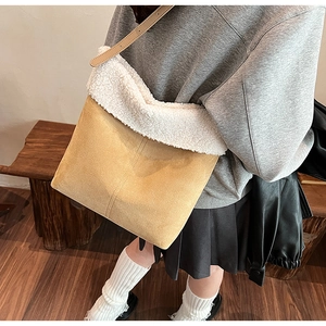 Dettaglio della borsa tote in pelle scamosciata marrone con bordo in ecopelliccia