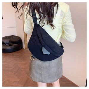 Detail of black corduroy crescent crossbody bag with ribbed texture on model back