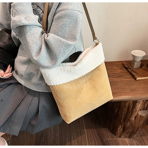 Dettaglio borsa tote in pelle scamosciata marrone con bordo in finta pelliccia bianca