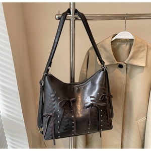 Dettaglio borsa a spalla vintage marrone scuro con fiocchi e borchie argentate