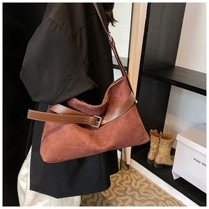 Détail du sac cabas en daim rouge rouille avec boucle décorative en cuir marron