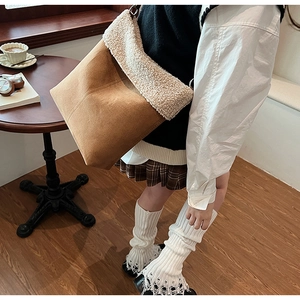 Dettaglio della trama della borsa tote in pelle scamosciata marrone con lana d'agnello