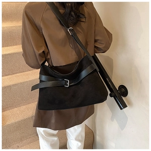 Détail du grand sac cabas noir en suédine avec bandoulière réglable portée par un mannequin