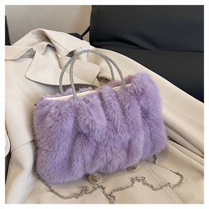 Gros plan du sac en fourrure violette avec poignées en strass et chaîne argentée