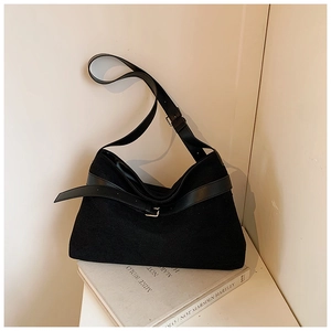 Détail d'un sac cabas noir minimaliste avec boucle argentée et bandoulière en cuir