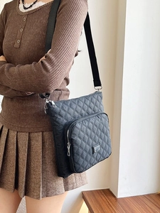 Women's black quilted crossbody bag with adjustable strap and diamond stitching