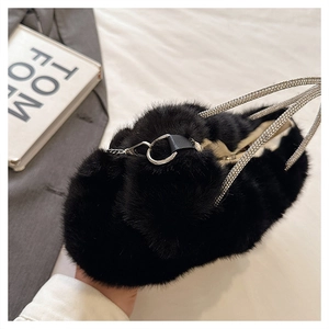 Détail du sac à main en peluche noire avec poignée en strass étincelante et sa chaîne