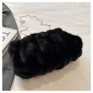 Détail d'un sac bandoulière noir en fausse fourrure pelucheuse avec chaîne argentée fine