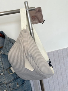 Light gray corduroy belt bag with thick ribbed texture and adjustable white strap