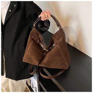 Detail of dark brown hobo bag with matte suede texture and gold buckle accents