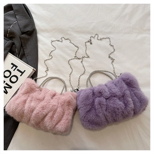 Détail des sacs nuages en fausse fourrure rose et violet avec poignées en strass