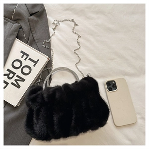 Détail du sac en fausse fourrure noire avec poignée en strass et chaîne en argent