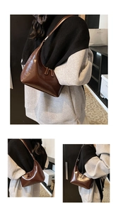 Dettaglio della borsa hobo marrone scuro lucida con forma a mezzaluna retrò e doppia zip