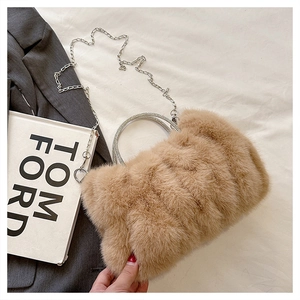 Détail d'un sac en fausse fourrure avec poignées rondes en strass et chaîne argentée