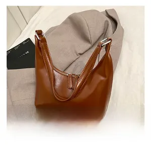 Dettaglio della borsa hobo in pelle caramello con doppia cerniera e anelli