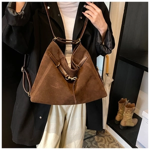 Detailed shot of brown suede hobo bag with dark leather handle and gold metal buckles