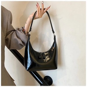 Dettaglio della borsa hobo in vernice nera con doppia cerniera e finiture argentate