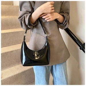Dettaglio della borsa hobo in pelle verniciata nera lucida con anelli in argento