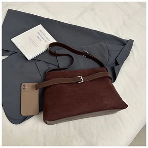 Détail du sac cabas en daim marron foncé avec sangle décorative en cuir et boucle en métal