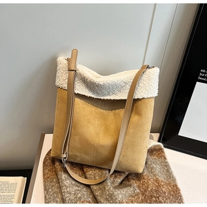 Dettaglio della borsa a secchiello in scamosciato zenzero con bordo in lana bianca