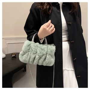 Détail du sac à main en peluche vert menthe avec texture plissée et bandoulière argentée