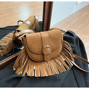 Detailed view of vintage dark brown saddle bag featuring tassels and matte suede texture
