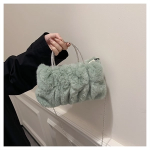 Détail du sac à main en peluche vert menthe avec poignées en strass et chaîne argentée