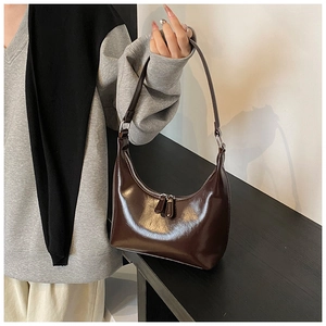 Dettaglio della borsa hobo marrone scuro in pelle verniciata lucida con zip argento