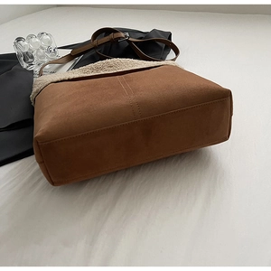 Dettaglio della borsa a secchiello in pelle scamosciata marrone con bordo in agnello