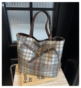 Detailaufnahme der Woll-Kariert-Tasche mit braunen Ledergriffen und Goldmetallschnallen