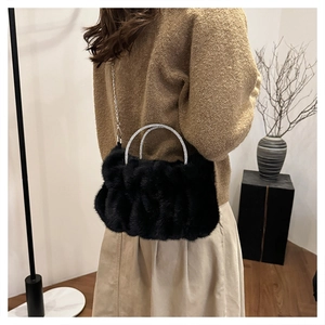 Détail du sac à main en peluche noir avec poignées en strass et chaîne argentée