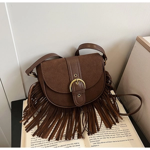 Detail view of deep brown suede saddle bag with vintage fringe and metal buckle accents
