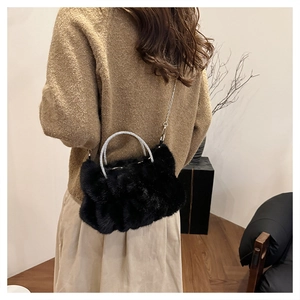 Détail du sac noir en fausse fourrure avec poignée en strass et chaîne en argent
