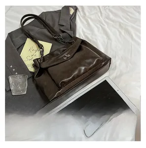 Dettaglio della borsa tote in ecopelle marrone scuro con catena e chiusura a girello