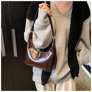 Dettaglio della borsa hobo marrone lucida con cerniera metallica e texture retrò