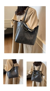 Detail of vintage black leather tote showing side zipper and backpack strap versatility