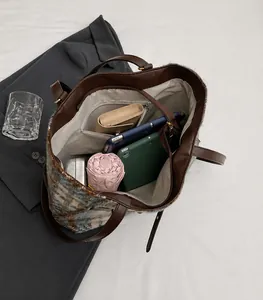 Makro-Detail des geräumigen karierten Tweed-Shoppers mit verschiedenen Inhalten