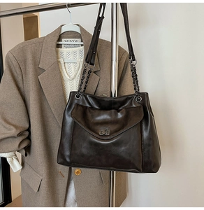 Dettaglio della borsa tote marrone scuro con trama stropicciata retrò e tracolla a catena