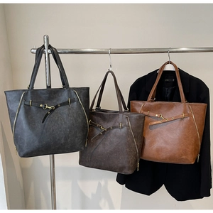 Detailed view of vintage large tote bags with side zippers and premium metal hardware accents